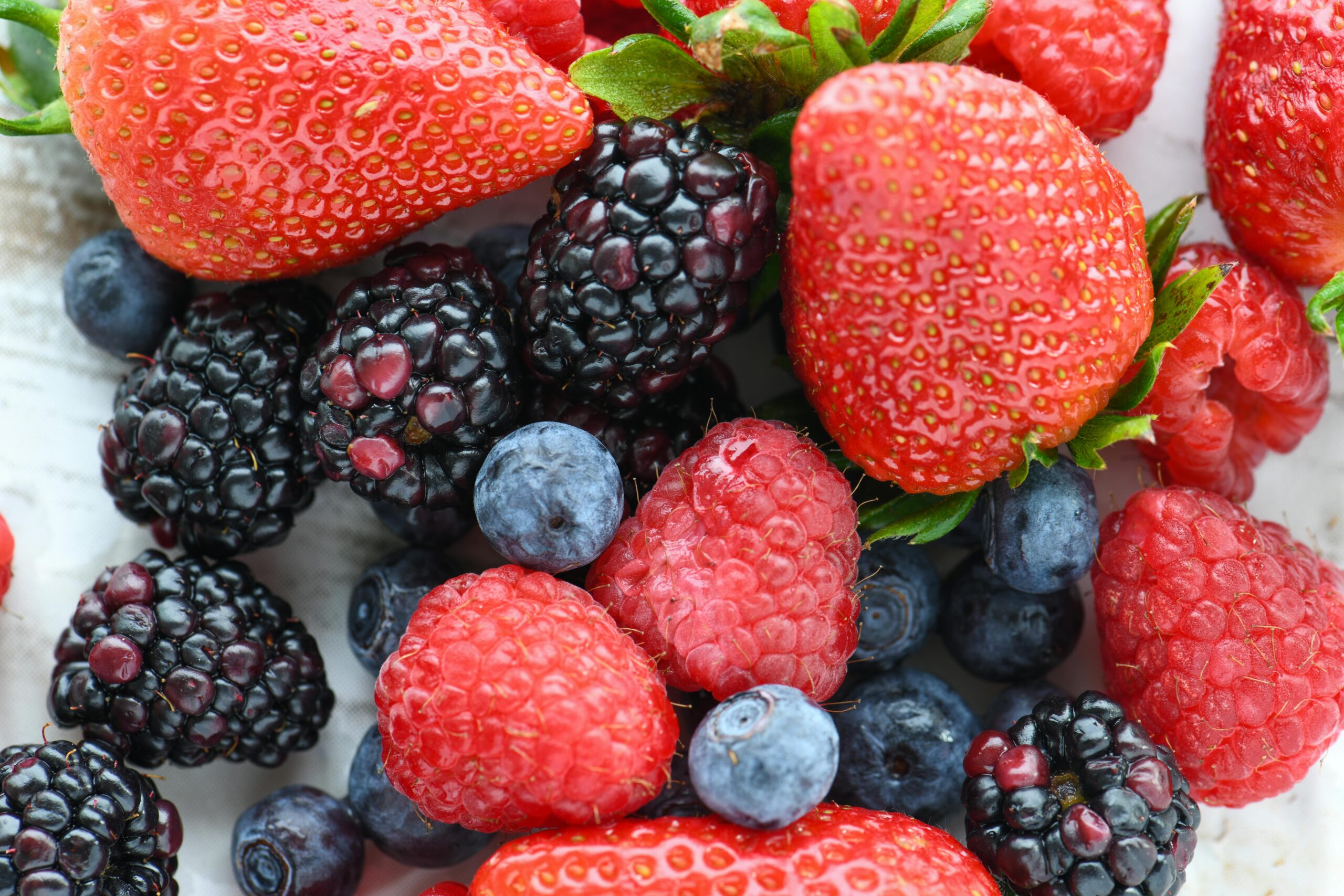 A vibrant close-up of fresh strawberries, raspberries, blackberries, and blueberries.